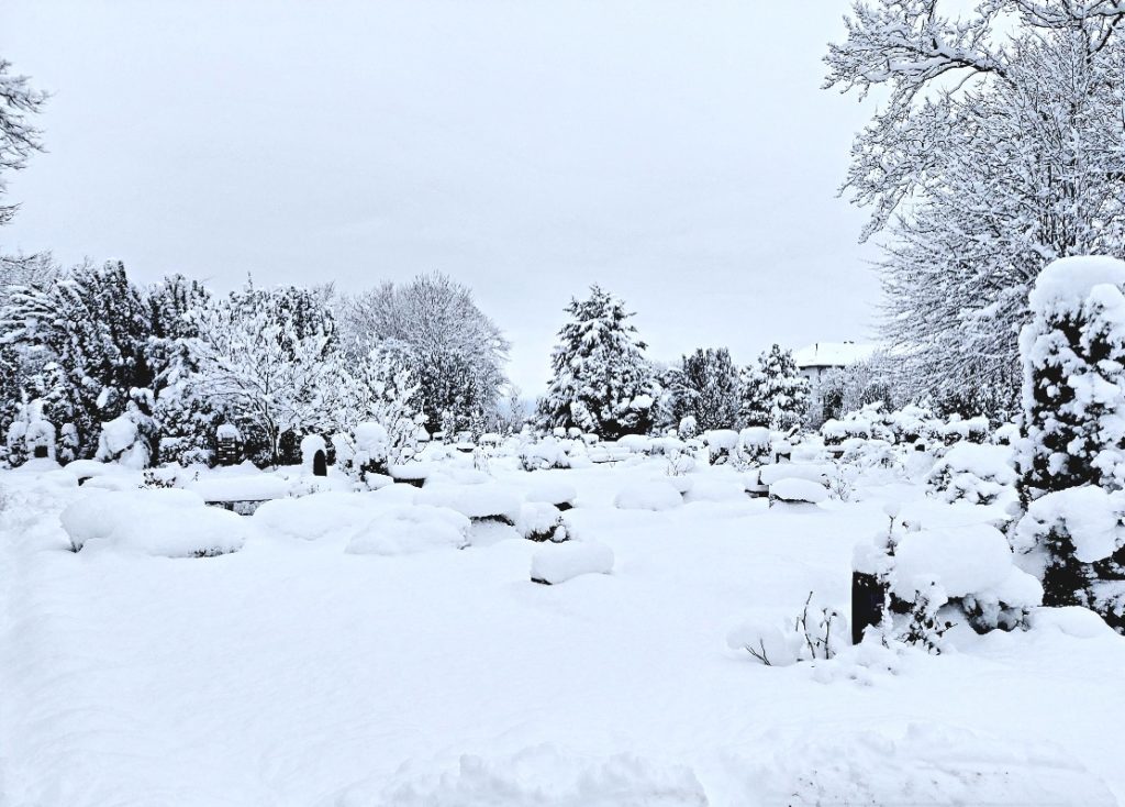 Grabmale sind mit Schnee bedeckt und kaum noch zu sehen.