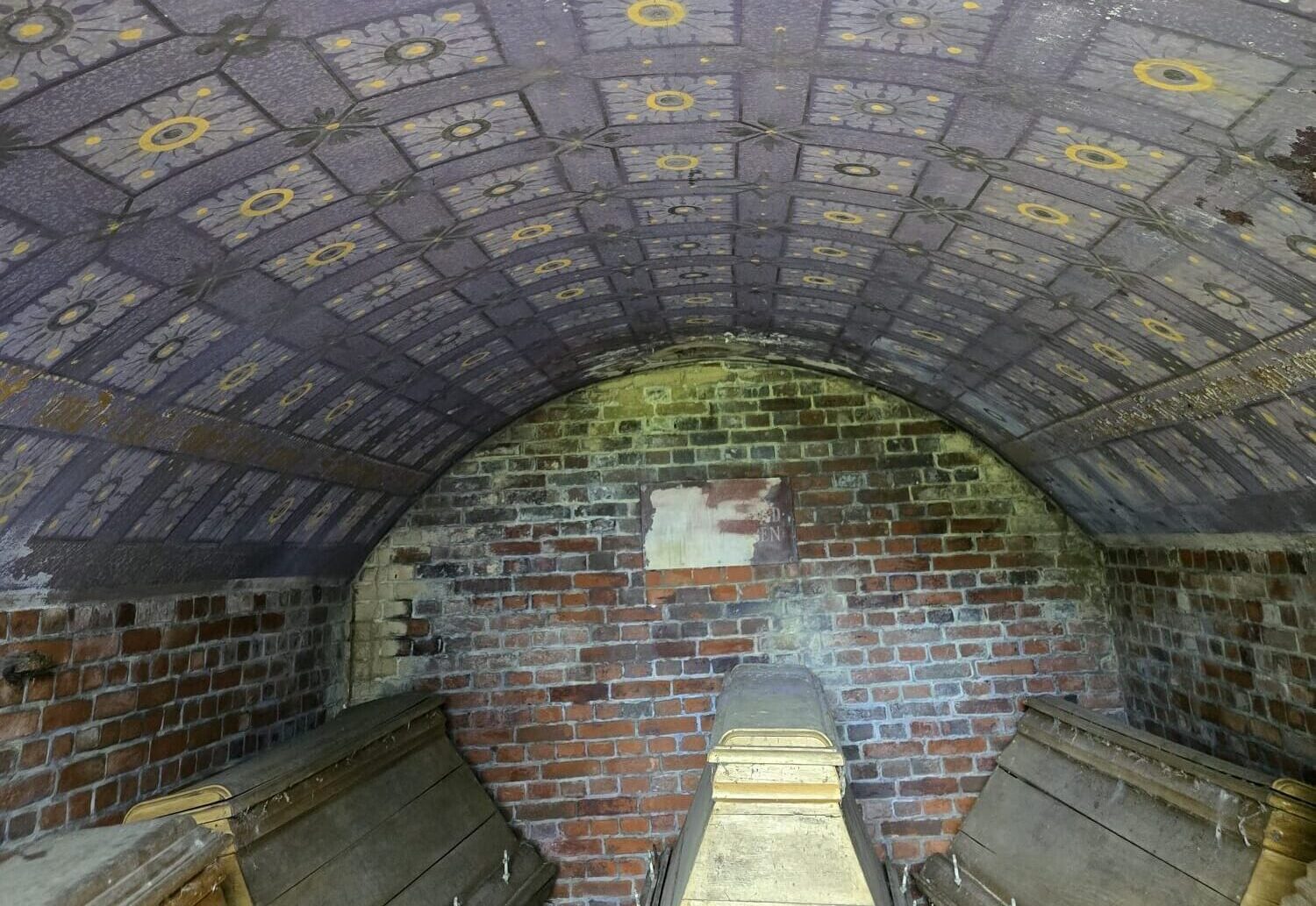 Innenansicht der Gruft, vier Holzsärge und eine aufwendig in blau und gelb bemalte Decke