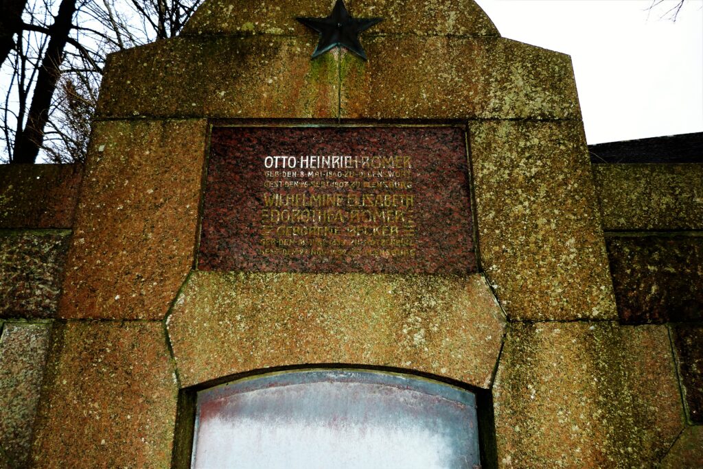 Schild mit Namen an einer gemauerten Gruft vor Sanierung kaum lesbar
